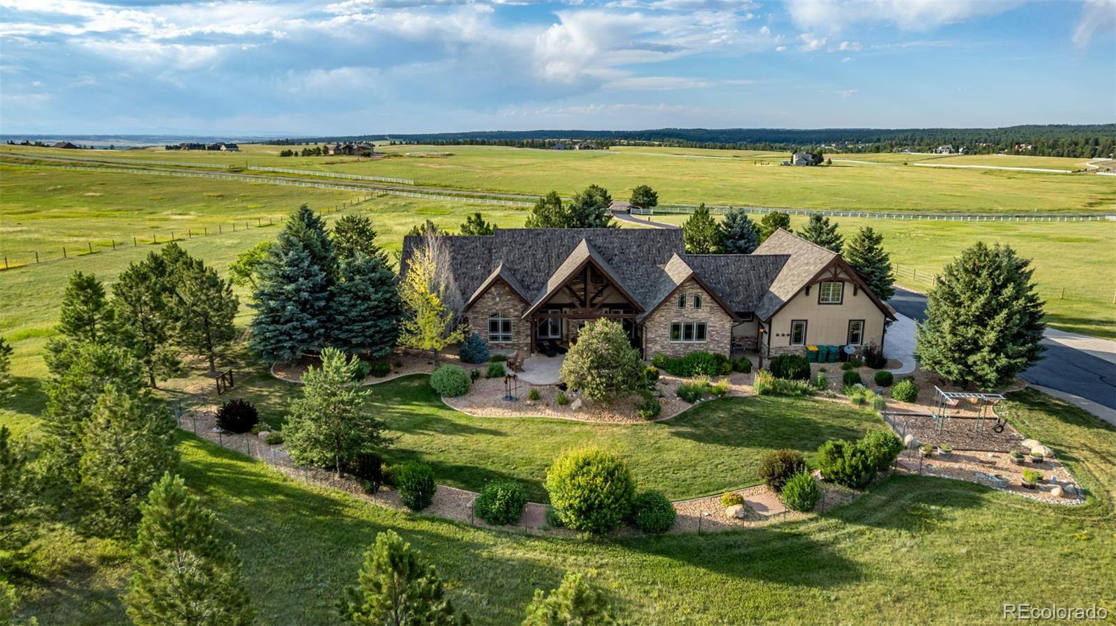 Aerial view of a stone and timber estate surrounded by evergreens and open pasture in Franktown
